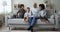 Happy grandfather and diverse grandson boys using smartphone on sofa