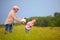 Happy grandfather with grandson having fun on summer field