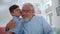 Happy grandfather and grandson hugging together in living room