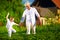 Happy grandfather and grandson walking among potato rows at their homestead