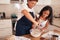 Happy grandma teaching granddaughter how to prepare batter for cupcakes