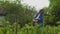 Happy Grandma in white hat Watering Plants in a Garden