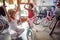 Happy grandmother and girl buying bicycle and helmets in bike shop