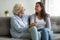 Happy grandmother and granddaughter holding hands, enjoying tender moment