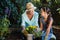 Happy grandmother and granddaughter planting flower pots