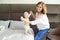 A happy grandmother plays with baby grandson on the bed.