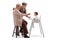 Happy grandparents feeding a baby in a chair