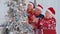 Happy grandparents, granddaughter toddler kid hanging balls decorating Christmas tree celebrating