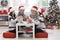 Happy grandparents with twin girls preparing for Christmas at home