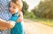 Happy grandson hugging to his grandmother outdoors