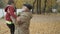 Happy grandson runs to grandfather in autumn park