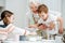 Happy granny holding her grandson, standing on a stool, reaching for the food