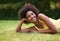 Happy, grass and portrait of black woman in garden for relaxing, calm and peace in park. Smile, nature and person laying