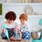 Happy great grandma and her great grandson cooking together at home kitchen