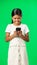 Happy, green screen and girl with smartphone, typing and laughing against a studio background. Mobile app, young person