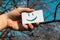 Happy green smile emoji paper card holding in hand