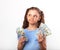 Happy grimacing doubt thinking kid girl holding money in the han