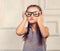 Happy grimacing kid girl in fashion glasses with fun emotional f