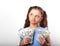 Happy grimacing thinking kid girl holding money in the hands and