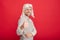 happy grizzled guy in sweater and earflap hat on red background show thumb up, fashion