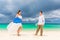 Happy groom and bride having fun on the sandy tropical beach. We