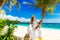 Happy groom and bride having fun on the sandy tropical beach under the palm tree. Wedding and honeymoon concept.