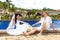 Happy groom and bride sitting by the pool. Wedding and honeymoon