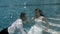 Happy groom and bride in white wedding dress sitting underwater on the bottom of the pool