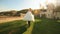 Happy groom carries on hands his charming bride. Young newlyweds having fun together at the medieval castle