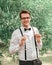 Happy groom straightening his bow tie in front of camera