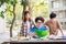 A happy group of attractive young people is tutoring exams with study books, sitting on the study table. Student group and