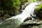 Happy group of Khmer children having fun at the waterfall on rainy day, near Thailand-Cambodia border