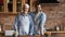 Happy grownup son and senior father in aprons cooking lunch