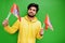 Happy Guru Nanak Jayanti concept. Young indian man in yellow sweatshirt hold flags. Cool south asian guy wear hoodie celebrating