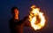 Happy guy artist perform fire circle by spinning burning poi on idyllic dark sky at night outdoors, orbital