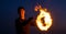 Happy guy artist perform fire ring by spinning burning poi on idyllic dark sky at night outdoors, circle