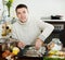 Happy guy cooking trout fish with onion