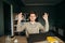 Happy guy freelancer in a shirt works at home on a laptop, looks at the camera and shows OK. Cheerful freelancer sitting. in the