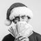 Happy guy holds fan money. Guy dream become millionaire. Santa helper holding cash money over grey wall, copy space. Christmas