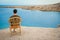 Happy guy sitting on a stool by the sea background on the nature