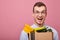 Happy guy in a sky blue shirt and glassesholds cardboard box with things in his hands