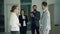 Happy guy in suit is getting job in company after successful interview, shaking hands and smiling expressing excitement