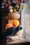 Happy Halloween. African Grey Parrot baby with flowers and pumpkins