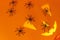 Happy Halloween! Black spiders decorations with spooky jack o lantern face on orange background. Creative Halloween composition.