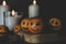 Happy Halloween citrus, tangerines painted with scary, funny faces. Dark photo with candles. Alternatives to traditional Halloween