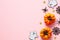 Happy Halloween concept. Flat lay composition with cute ghosts, orange pumpkins, spiders, confetti on pink background. Top view,