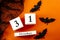 Happy Halloween and fall holiday concept with a calendar showing october 31, bats and black spider web