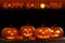 Happy Halloween. Glowing Jack O`lanterns on table in darkness