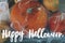 Happy Halloween greeting card. Hand written Happy Halloween text on background of spooky pumpkins in cobweb with spiders