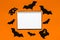 Happy halloween holiday concept. Notepad for text on white and orange background with bats, pumpkins and ghosts